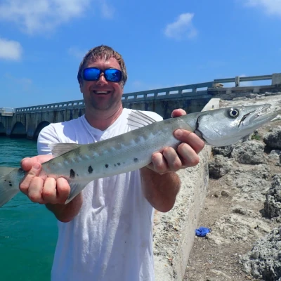 Nick Honachefsky holding a fish while standing in front of the Channel #2 bridge in Islamorada