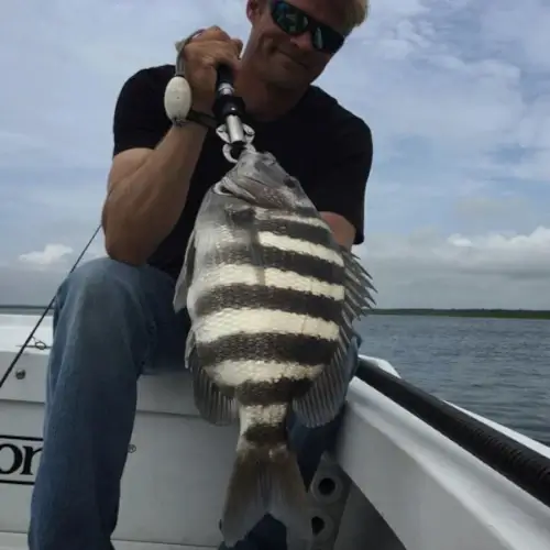 Dan Schafer holding a fish with a fish grip