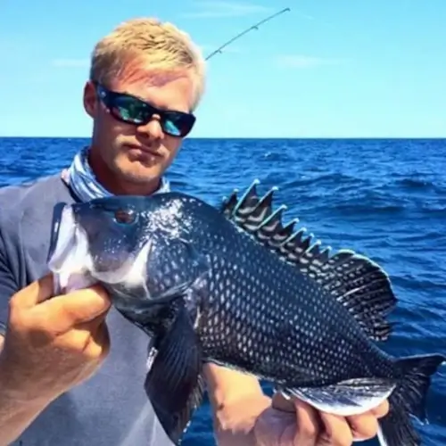Dan Schafer holding a black fish