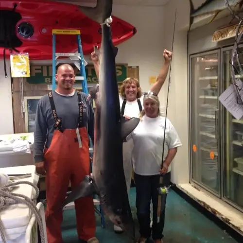 Maureen Klause and two other anglers showing off a shark